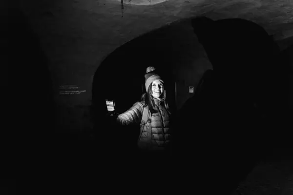 ダンジョン 古代の要塞の暗いトンネルで観光客 ストックフォト
