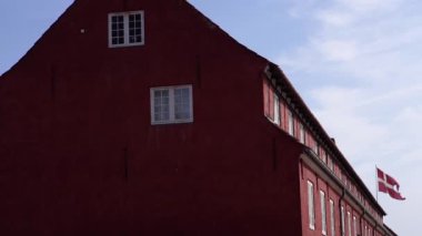 Danimarka bayrağı. Bayrak kırmızı bir binada asılı..