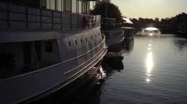 Zevkli tekneler. Batan güneşin arka planında demirlemiş kayıklar..