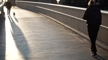 Köprü. İnsanlar şafakta köprü boyunca hareket ederler. Danimarka. Kopenhag.