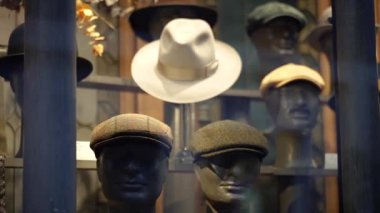 Farklı şapkalı bir vitrin. Camın arkasındaki klasik başlık..