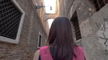 Venedik. Eski kasabadaki dar bir sokakta bir turist yürüyor..