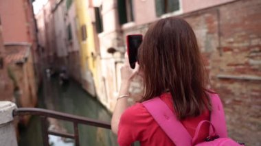 Venedik. Bir turist telefonunda dar bir kanalı çekiyor..