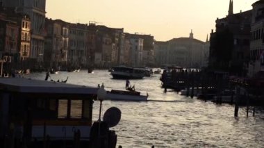 Venedik 'te bir sürü tekne var. Kürekli bir gondolcu gondolcuyu kontrol eder..