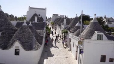 Apulia. İtalya. 14 Ekim 2023. Apulia 'daki Trulli. Turistler trulli ile şehirde dolaşıyorlar.