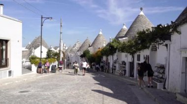 Apulia. İtalya. 14 Ekim 2023. Apulia 'daki Trulli. Turistler trulli ile şehirde dolaşıyorlar.