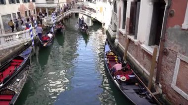 Venedik. İtalya. 14 Ekim 2023. Bir gondolcu bir tekneyi idare eder. Bir gondol, insanlarla birlikte kanalda yüzer..