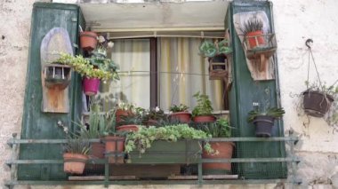 Pencere çiçeklerle süslenmiş. İtalya 'nın güneyinde balkon dekorasyonu. Sokaktan bak..