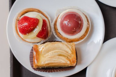 Pişirme. Pastalar beyaz tabakta. Genel plan.