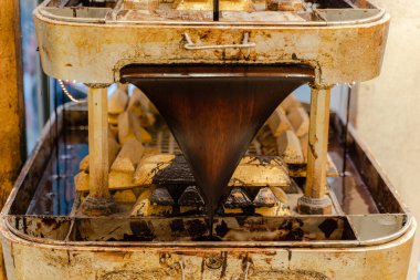 Altın külçeleriyle süslenmiş çikolata çeşmesi. Yakın plan..