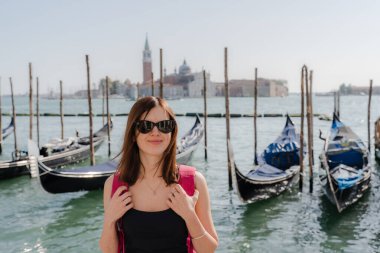 Venedik. Bir turist, arka planda bir kanalla köprü boyunca yürür..