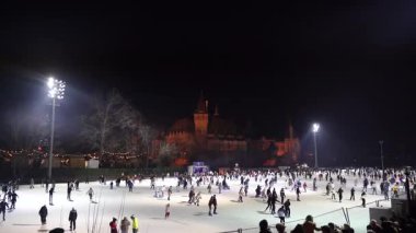 Budapeşte. Macaristan. 25 Aralık 2023. Gece şehri. Açık hava buz pateni pisti. İnsanlar kayıyor..