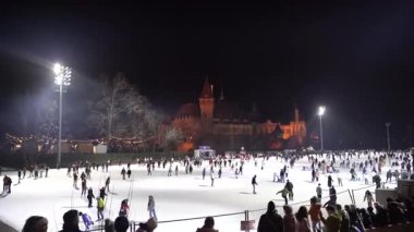 Budapeşte. Macaristan. 25 Aralık 2023. Gece şehri. Açık hava buz pateni pisti. İnsanlar kayıyor..