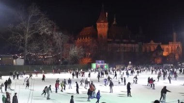 Budapeşte. Macaristan. 25 Aralık 2023. Gece şehri. Açık hava buz pateni pisti. İnsanlar kayıyor..