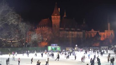 Budapeşte. Macaristan. 25 Aralık 2023. Gece şehri. Açık hava buz pateni pisti. İnsanlar kayıyor..