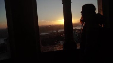Şafak Bir kadın izleme platformunda bir caddede duruyor ve şehre bakıyor..