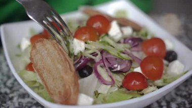 Salata. Bir kadın çatalla salata karıştırıyor.. 