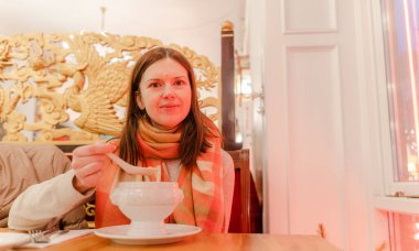 Yiyecekler. Bir kadın kafede çorba içiyor..