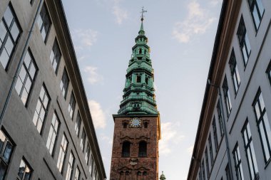 Mimarlık. Evlerin arasında uzun bir kilise saat kulesi..