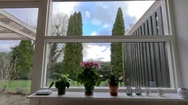 Zaman ayarlı. Bulutların üzerindeki pencereden ve yeşil bahçeden bak. 