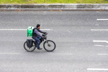 Lizbon, Portekiz 'de 11 Mart 2024' te Uber Eats çalışanı koruma veya ışık sinyali olmadan Lizbon 'da yola çıkıyor.