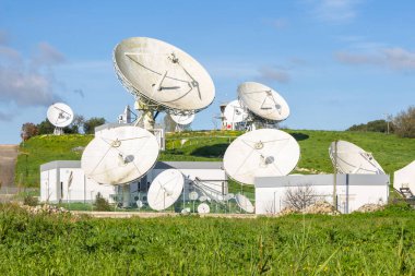 Sintra, Portekiz 'deki kıta uydu operasyonel merkezinde mavi gökyüzüne karşı uydu antenleri dizisi.