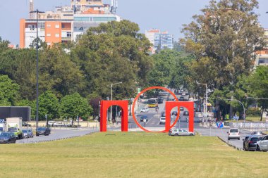 Şehir fotoğrafı, ikonik modern sanat eserini, Lizbon metro anıtını, hareketli şehir yaşamının ortasında çekiyor.