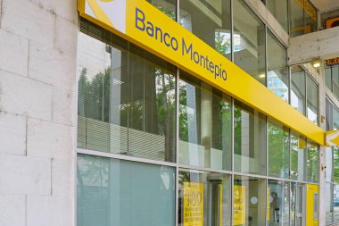 Banco Montepio 'nun modern banka şubesinin güneşli sokak manzarası. Canlı bir şehir çevresi. Banka logosu ve Portekiz' in hareketli şehrine bir bakış.