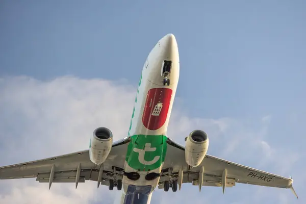 stock image Close up of a transavia boeing 737 8k2 aircraft mid flight against a cloud speckled blue sky