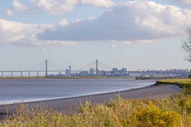 Vasco da gama köprüsü ve Lisbon siluetinin manzaralı görüntüsü, tagus nehri ön planda parçalı bulutlu bir günde