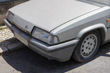 Close up of an old citroen bx 16 trs parked on a street, highlighting its vintage design and deteriorated condition clipart