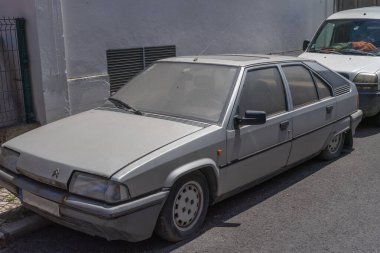 Eski, gri citroen bx 16 trs bir şehir caddesinde, soluk boyası ve tozlu dış görünüşü zamanın hikayesini anlatıyor ve