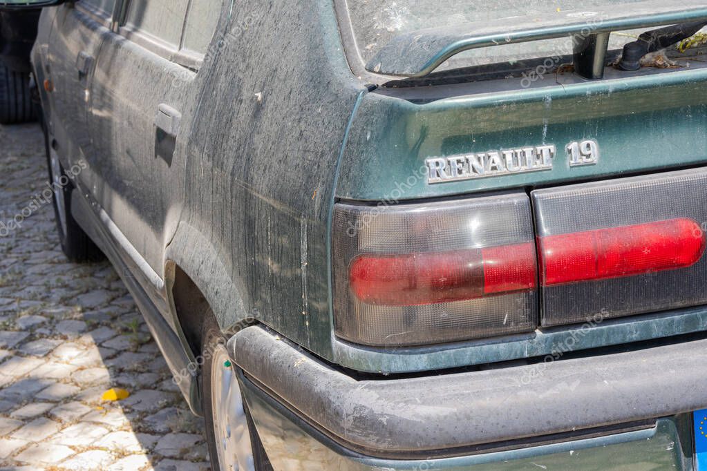 Close up of a dirty green renault 19 rti parked on a cobblestone street, showing its age and wear