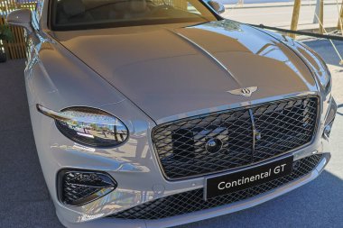 Yepyeni Bentley Continental gt 'in zarif ön yüzü güneşin altında parlıyor.