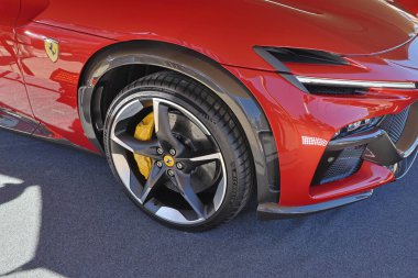 Kırmızı ferrari sf90 stradale yakın çekim ön tekerleğin karmaşık tasarımı ve aerodinamik tampon