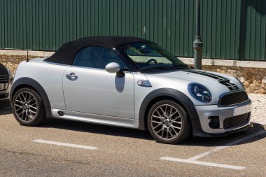 Silver Mini Cabrio Cooper güneşli bir günde sokağa park eder.