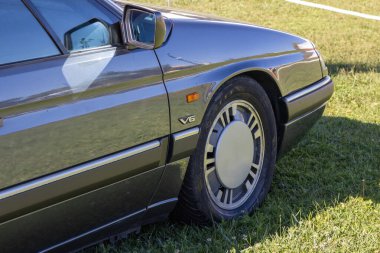 Citroen xm v6 with alloy wheel parked on a grass field during a sunny outdoor car exhibition clipart