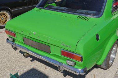 Green ford escort mk1 parked on a sunny day, showcasing its classic design and chrome details clipart