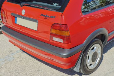 Güneşli bir günde kırmızı Volkswagen Polo GT otoparka park etmiş.