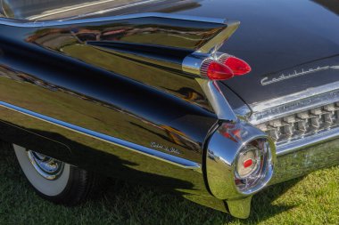 Klasik Cadillac coupe Deville otların üzerine park edip ünlü kuyruk yüzgeçlerini gösteriyor.