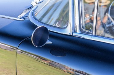 Chrome shines on a vintage cadillac coupe deville with a deep black paint job reflecting the sky clipart