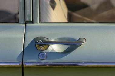 Eski bir Chevrolet Corvair 'de krom kapı kolu güneşte parlıyor.