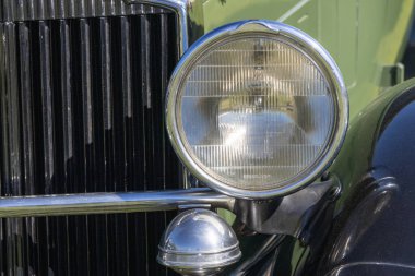 Parlak krom farlı klasik araba güneşte parlıyor.