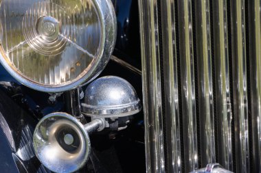 Parlak krom parçaları, klasik tasarımını sergileyerek, eski bir rulo Royce 'un önünde parlıyor.