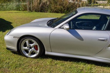 Side view of a silver porsche 911 turbo parked on grass clipart