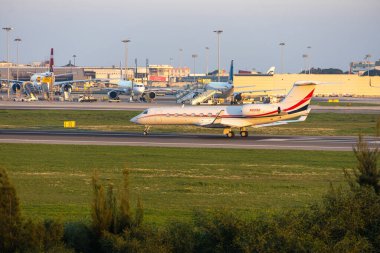 Gulfstream g550 iş jeti arka planda diğer uçaklar ile Lizbon havaalanı pistinde taksicilik yapıyor.
