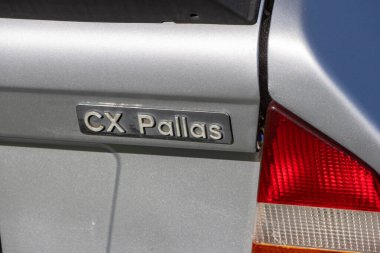 Citroen Cx Pallas 'ın gümüş bir arabanın üzerindeki logosuna yakın plan, klasik aracın zarif tasarımını vurguluyor.