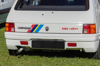 White peugeot 205 rallye parked on grass, its iconic design and rally heritage evident in its lines and badging clipart