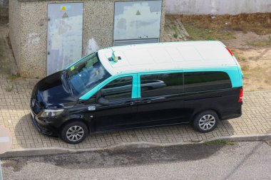 Black and teal lisbon taxi is parked on the sidewalk clipart