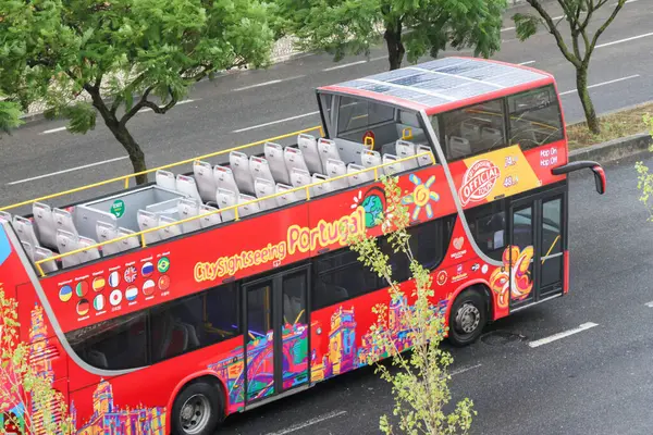 Parlak kırmızı şehir turu çift katlı otobüs Lizbon Portekiz 'de caddede ilerliyor.